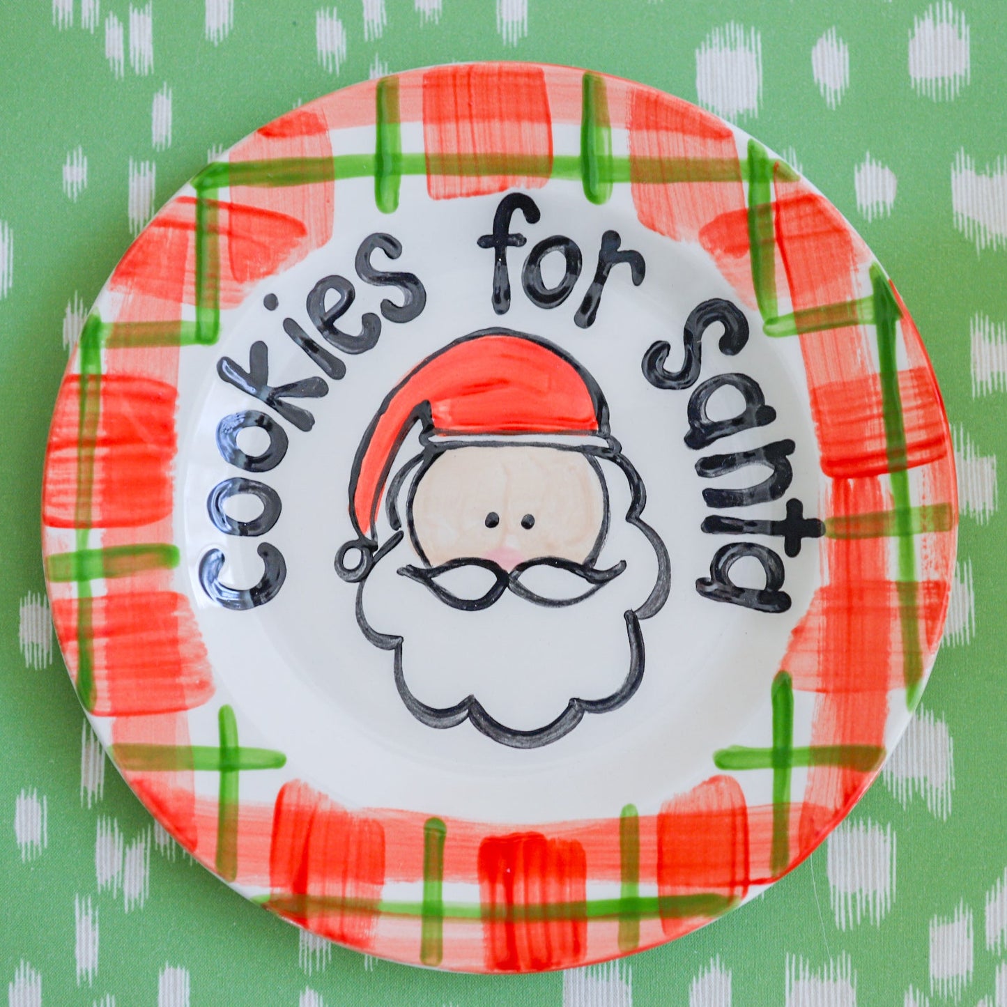 Decorative plate with 'Cookies for Santa' text and Santa Claus illustration on a green background.