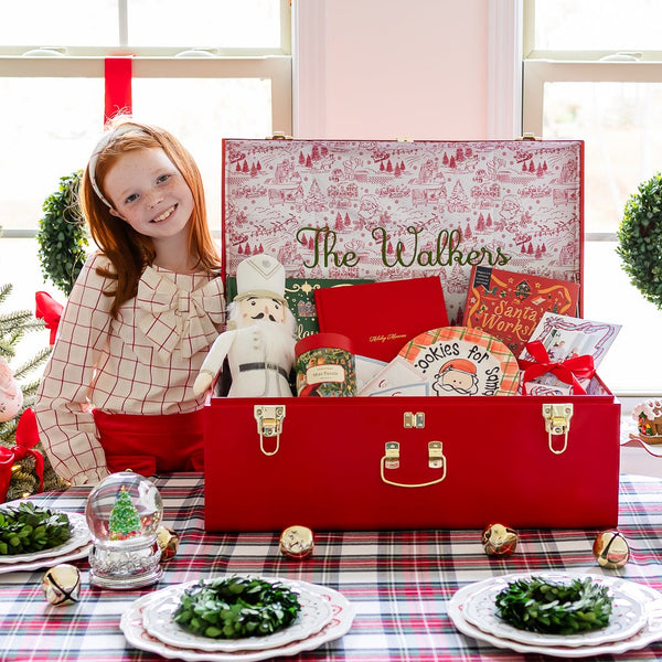 Decorated Christmas table with a red Trunk labeled 'The Walkers' and festive decorations.