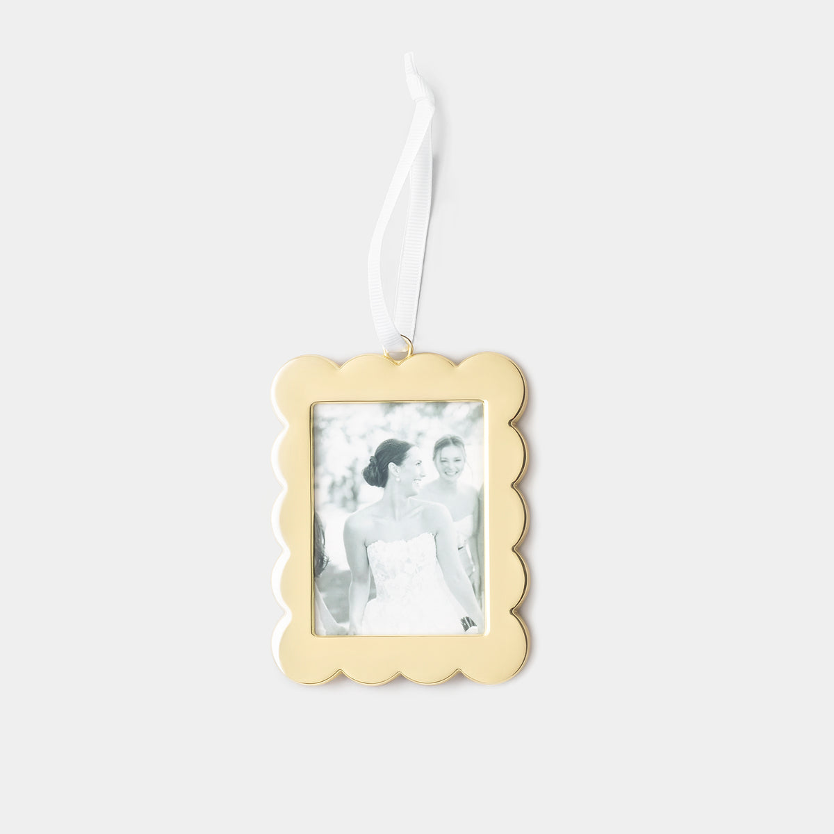 A gold scalloped-edge rectangular photo ornament with a white hanging ribbon, featuring a placeholder black-and-white wedding photograph, shown against a light gray background.